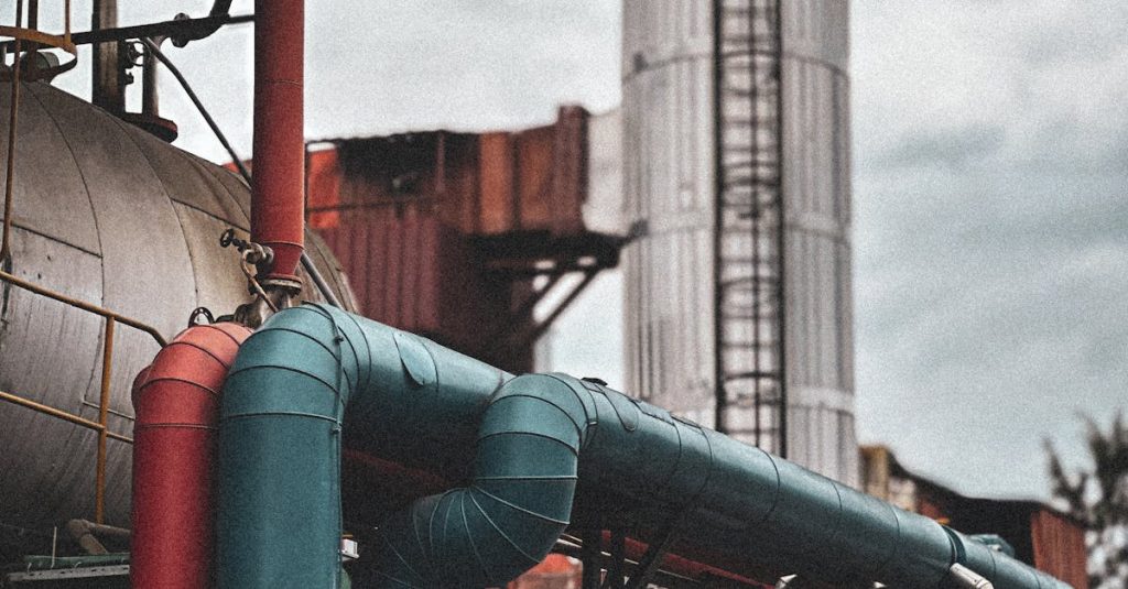 View of an industrial facility showcasing colorful pipes and structures under a cloudy sky.